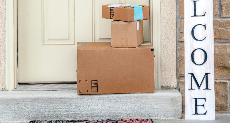 Packages on the doorstep of a home with a welcome sign in Akron